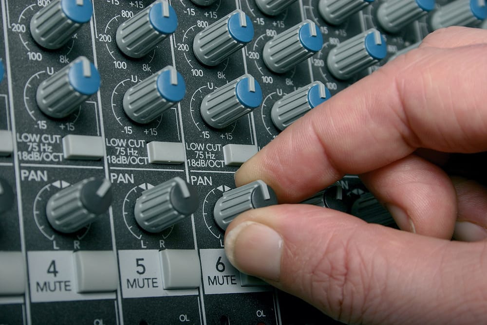 Ajustement du panoramique sur une console de mixage audio.